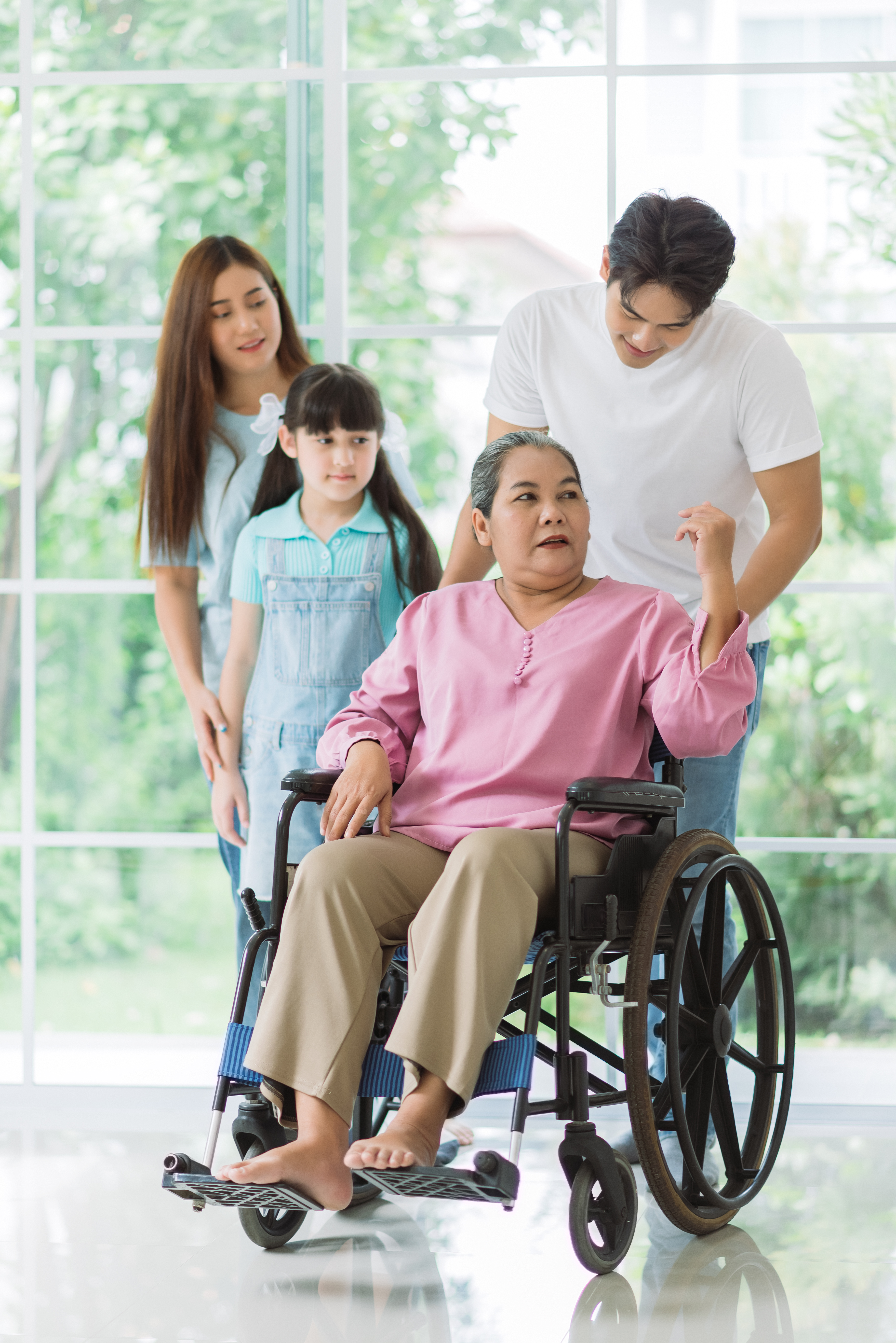 Happy asian family spending time together on vacation at home, grandmother on wheelchair with family